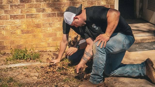 F5 plumber evaluating an exterior ground-line opening at a Big Country property