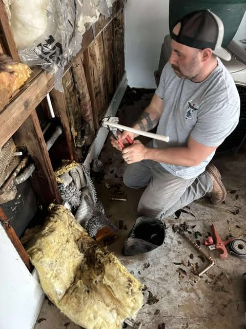 F5 plumber fitting pipe during an open-wall plumbing repair