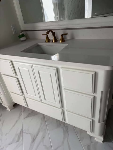 Finished white bathroom vanity with gold faucet