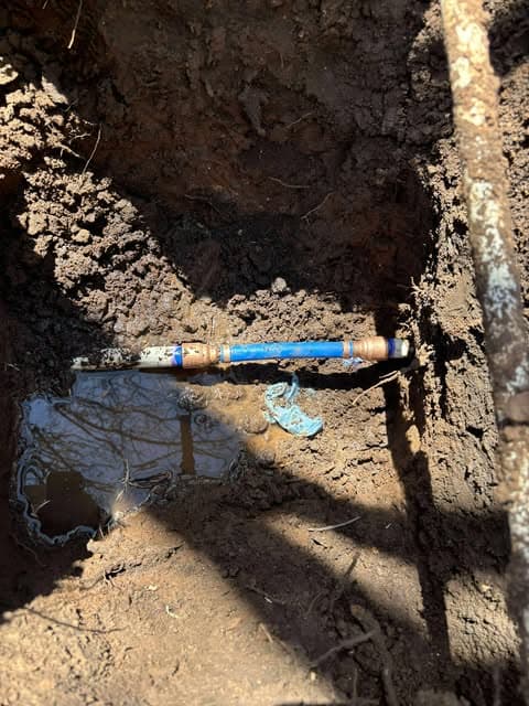 Exposed underground blue water line with a new repair connection